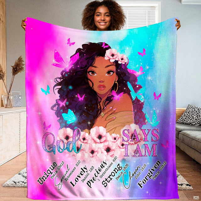 Woman holding up an inspiring blanket portraying a Black woman with butterflies, pink blooms, and faith text.