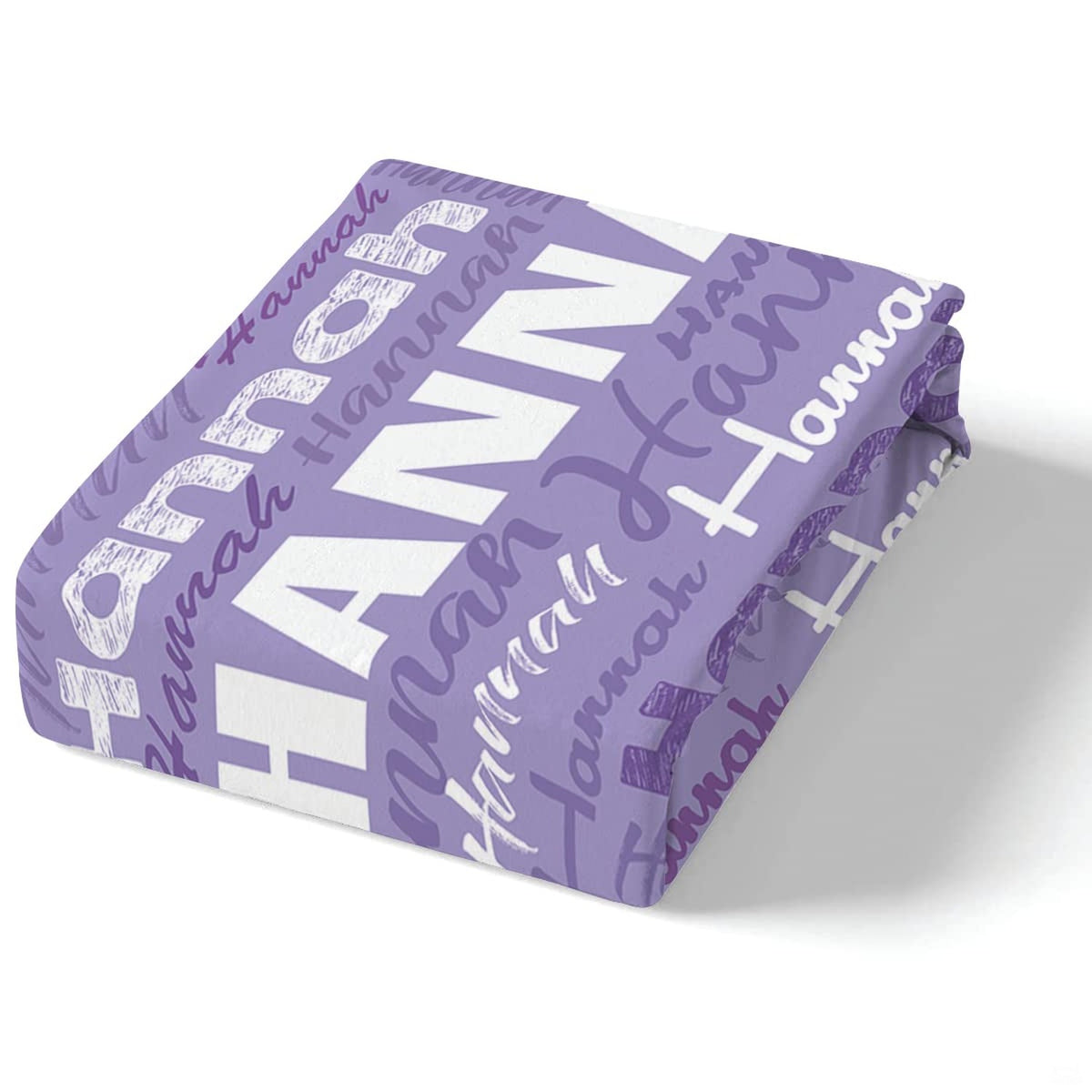 Coordinated bedding presentation showcasing lavender typographic collage patterns and matching accents.