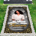 Gilded arch memorial remembrance grave blanket displayed on lawn framed by white stones