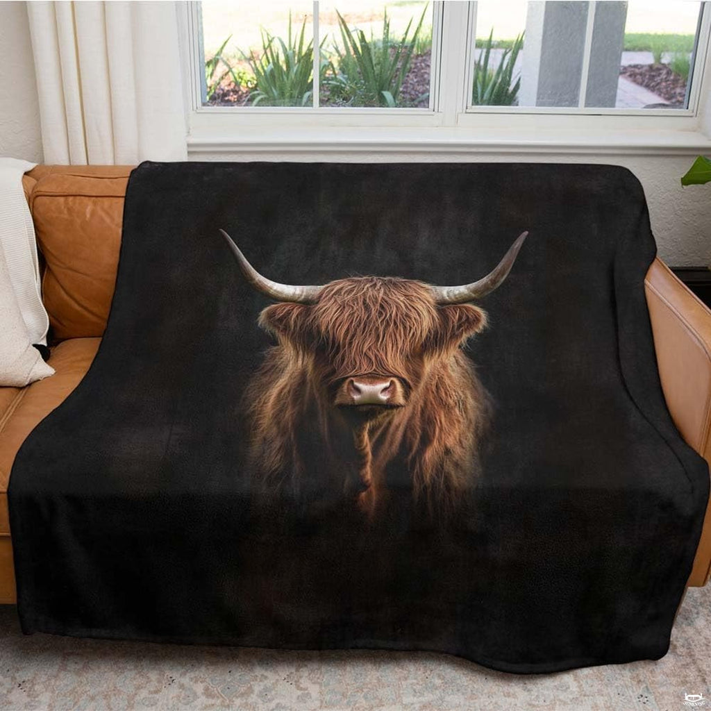 Dramatic portrait of Scottish Highland cow with curved horns emerging from black background, view 4.