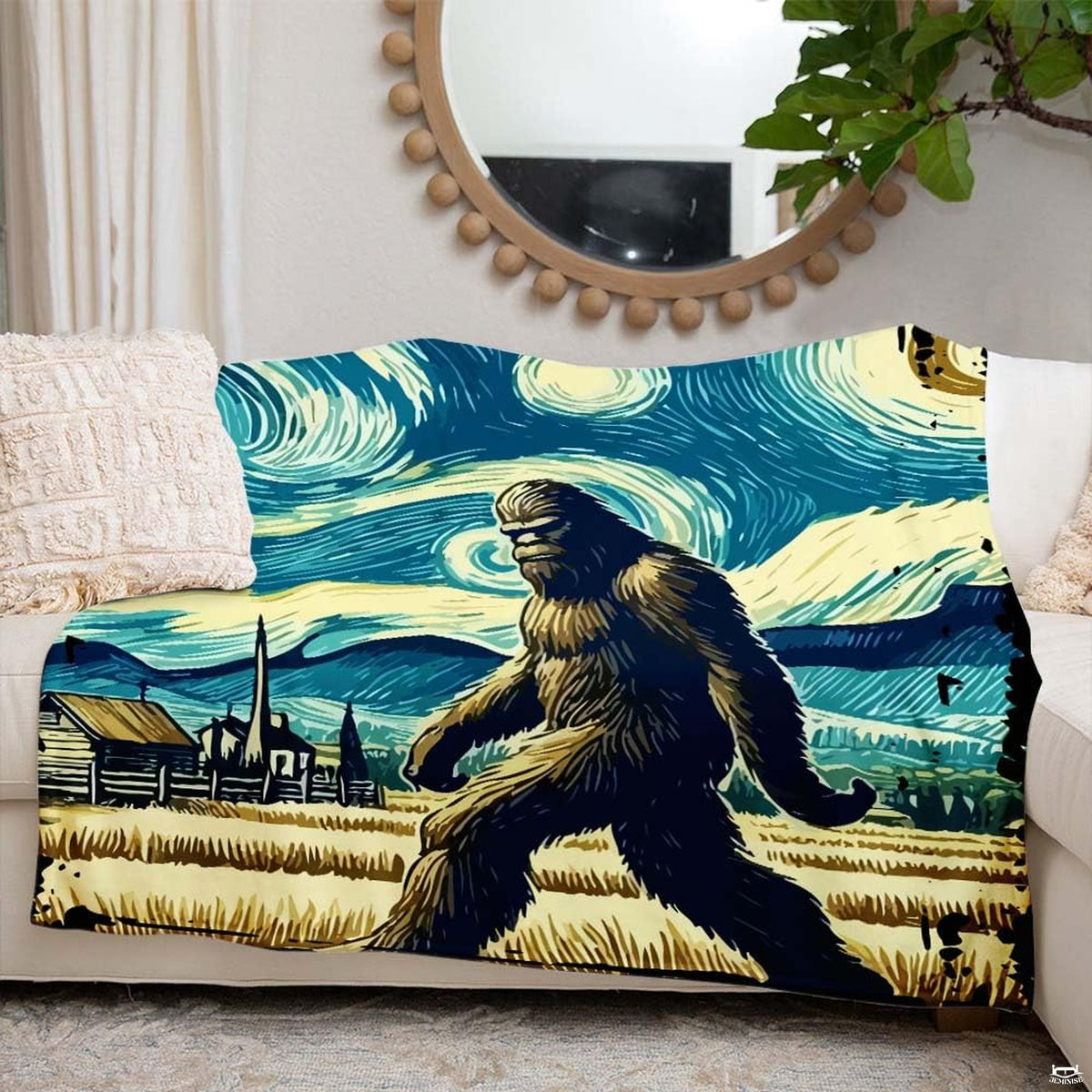 Artistic Bigfoot throw blanket arranged on a cream couch beside round mirror