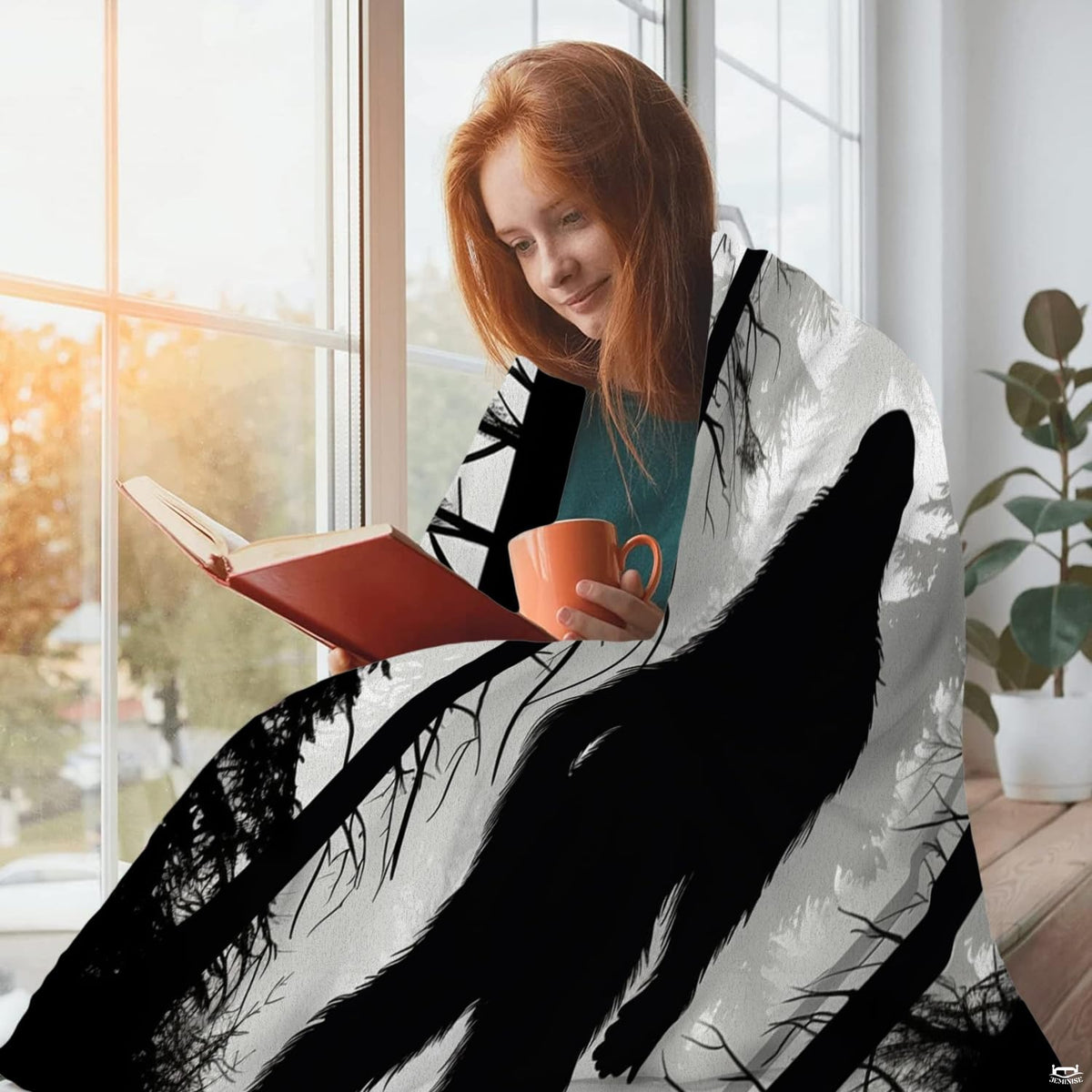 Person sitting beside a window with a mug and book while draped in the misty forest Bigfoot textile.