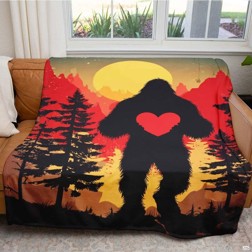 Bigfoot holding heart throw blanket view 5 highlighting Sasquatch silhouette, scarlet heart, and sunset sky