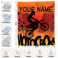 Orange motocross racing throw blanket folded neatly on bedroom chair