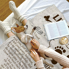 Person resting indoors with dog on lap covered by memorial butterfly blanket.