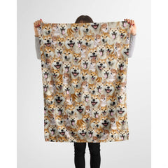 Model holding up repeating shiba inu puppy face blanket in studio