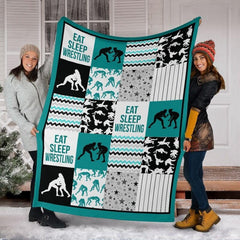 Detail view of neat hemmed edge and high-contrast printing on teal wrestling blanket.