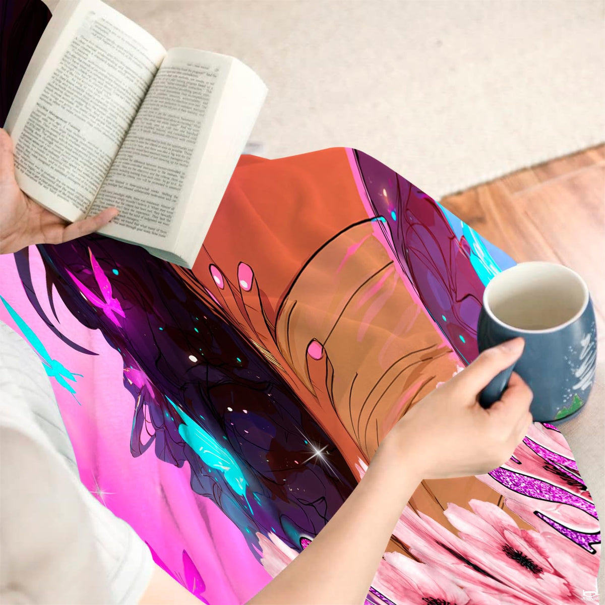 Person sitting indoors with a book and coffee while draped in the printed inspirational textile.