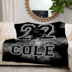Detailed view of oversized varsity jersey numbers and billowing white smoke on football throw blanket