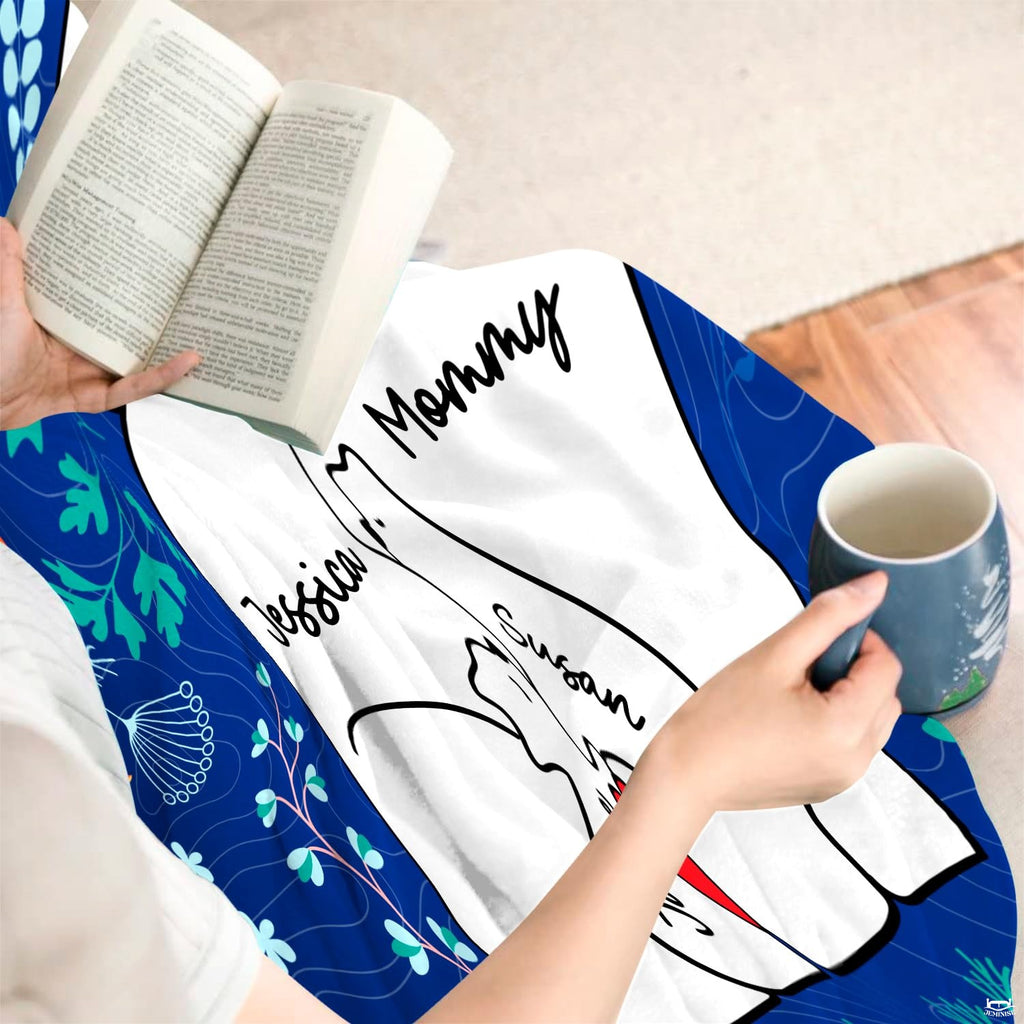 Close-up perspective of embracing polar bear cubs and red heart on navy floral throw blanket