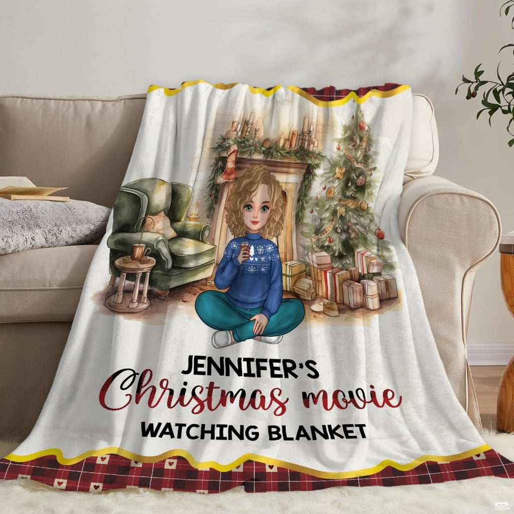 Living room staging of holiday throw blanket draped across a neutral sofa beside books.