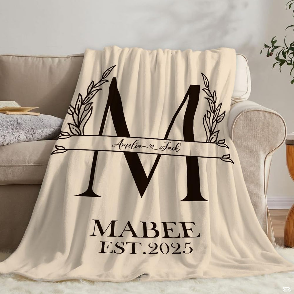 Detail shot of black typography and botanical leaf print on cream throw blanket