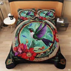 Overhead view of oval hummingbird bedding with red flowers and gold trim