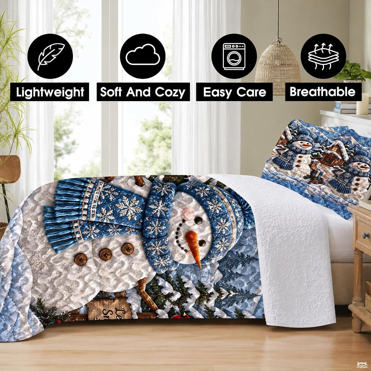 Festive bedding display with a snowman, pine trees, and rustic log cabin in a snowy mountain scene.