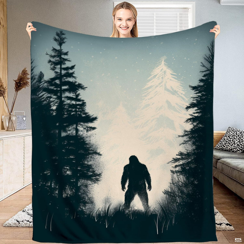 Bigfoot winter forest snowy pine blanket featuring Sasquatch silhouette in falling snow.