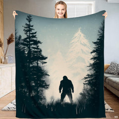 Bigfoot winter forest snowy pine blanket featuring Sasquatch silhouette in falling snow.