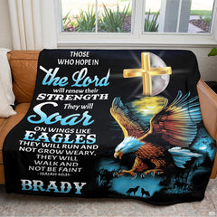 Devotional nature throw blanket folded and displayed neatly over a brown armchair cushion.