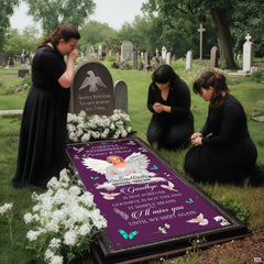 Mourners in black dresses gathered reverently beside installed purple angel memorial blanket