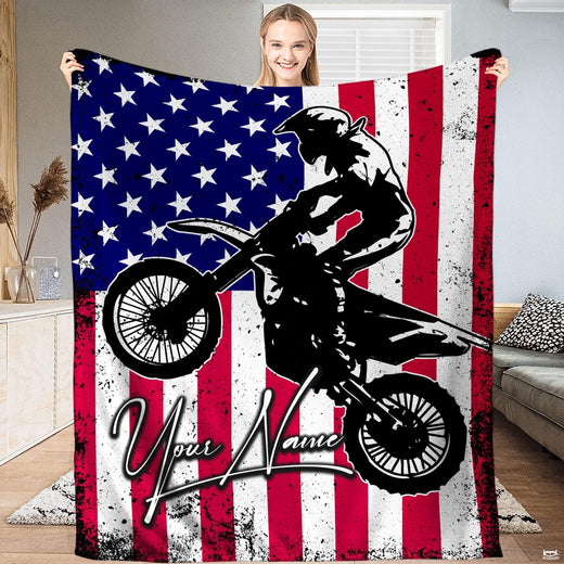 Dirt bike rider silhouette jumping over distressed American flag stars and stripes, view 1.
