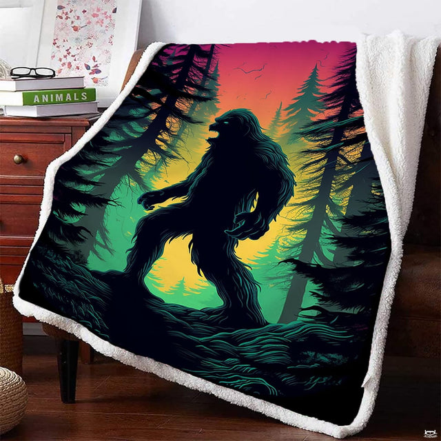 Bigfoot sunset blanket draped on armchair featuring Sasquatch in evergreen forest.