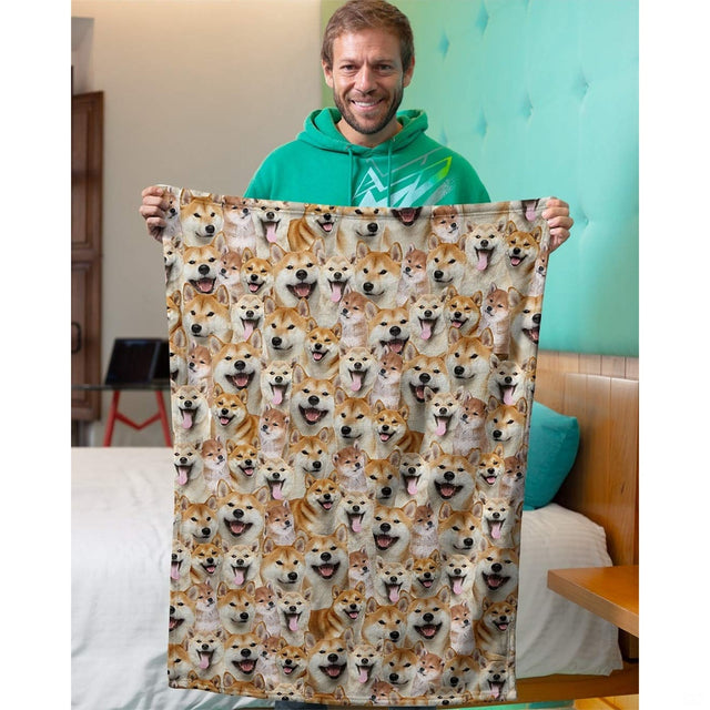 Man holding upright smiling shiba inu dog face collage blanket in bedroom