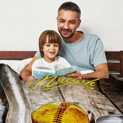 Father and son reading a book together in bed beside the displayed sports graphic piece.