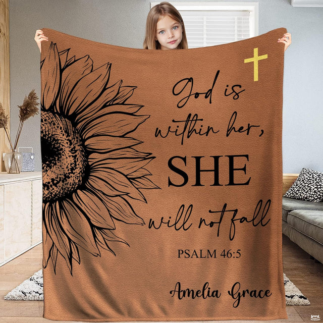Full view of throw blanket held up, showing black sketched sunflower, golden cross, and scripture calligraphy.