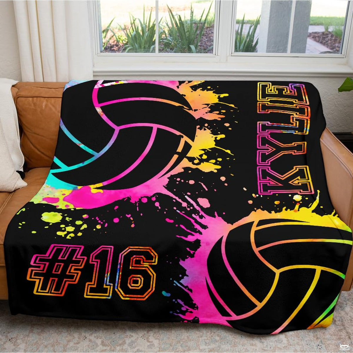 Close view of dynamic watercolor paint splatters and stylized volleyball illustrations on colorful bedding.