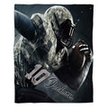 Flat view of camo football blanket displaying military uniform athlete charging forward on dark backdrop