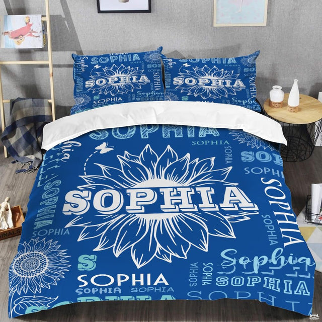 Overhead view of blue floral bed sheets showcasing sunflower graphics and whimsical trail details.