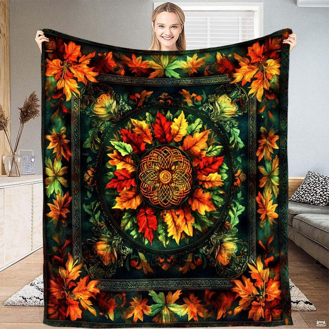 Model displaying throw blanket featuring circular Celtic autumn leaf mandala with amber and red foliage