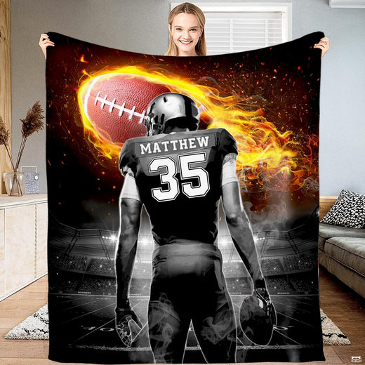 Football player beneath a blazing flaming football in a stadium, view 1.