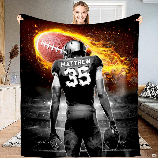 Football player beneath a blazing flaming football in a stadium, view 1.