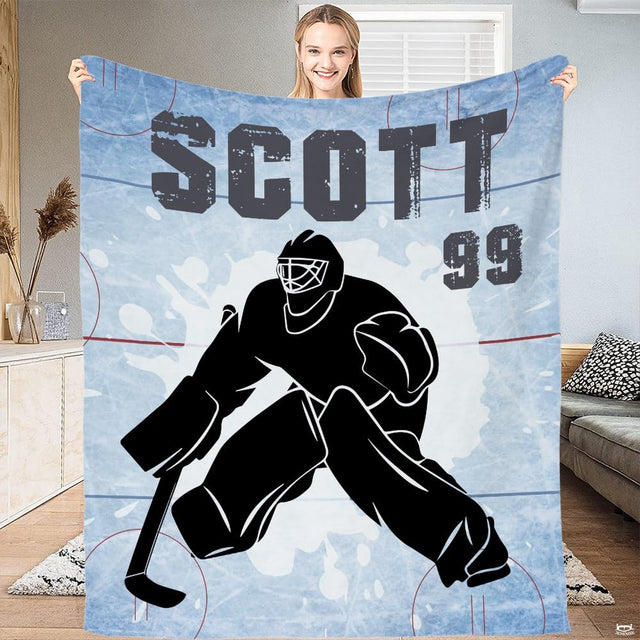 Full flat view of hockey goalie throw blanket showing distressed varsity lettering and rink lines.