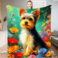 Yorkshire terrier puppy resting amid bright wildflowers on teal bedding