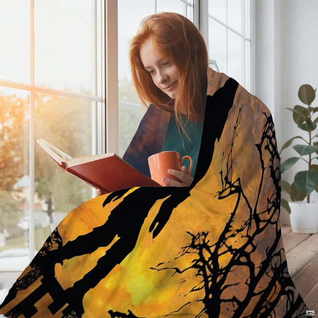 Bigfoot sunset silhouette throw blanket styled over a sofa in a living room.