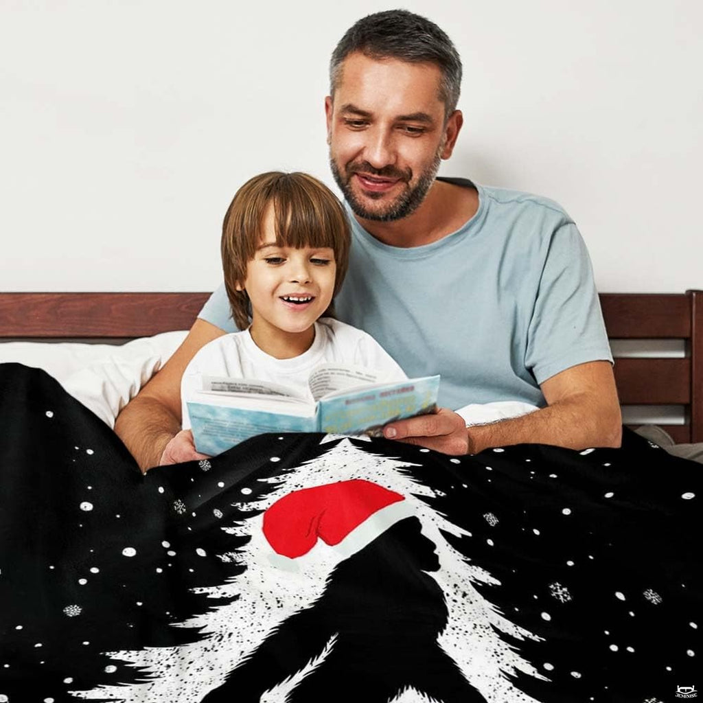 Christmas Bigfoot throw blanket view 3 highlighting Santa hat silhouette, falling snow, and festive tree