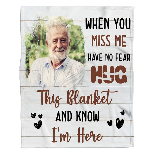 Flat display of tribute throw blanket featuring wood grain background, foliage portrait border, plus lettering.