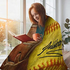 Vintage fastpitch ball in fielder mitt textile display on living room sofa