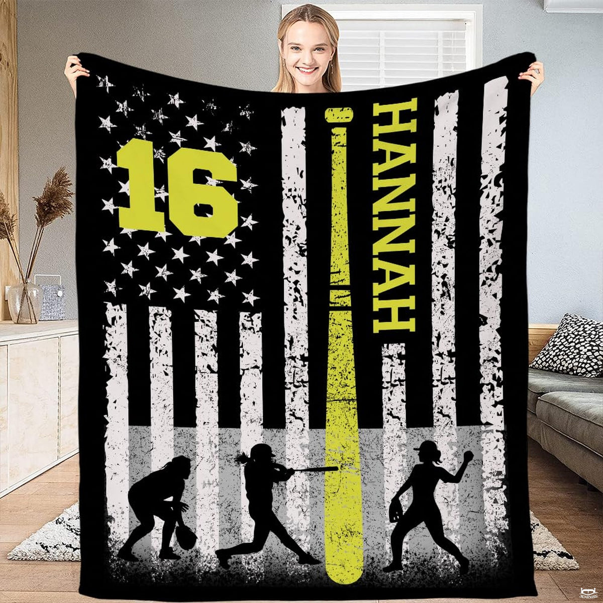 Person standing in living room holding up the softball flag print with neon bat accent.