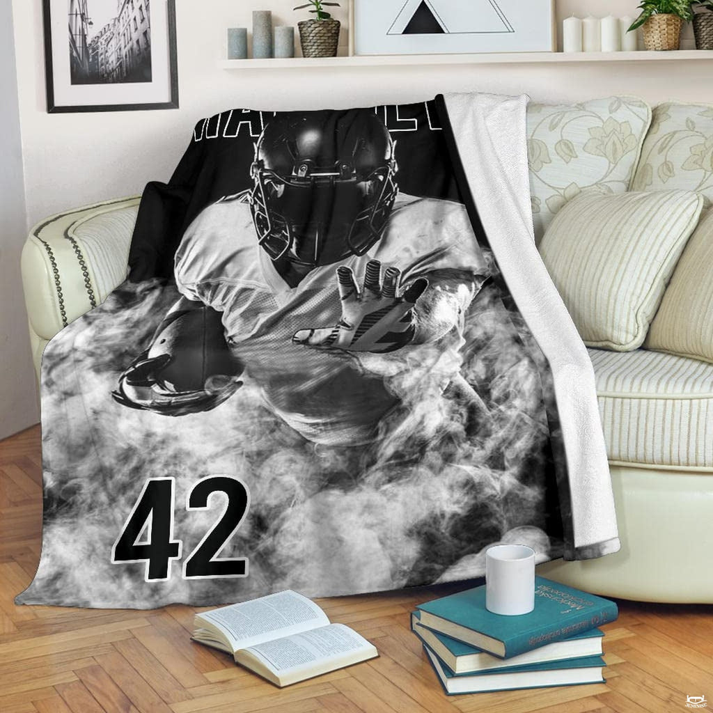 Black and white football graphic blanket styled across bedroom bed