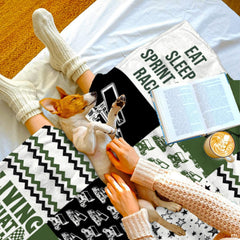 Close up view of thematic accent vehicle artwork, chevron patterns, and star motifs on an olive green patchwork bedding set.