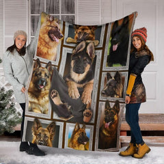 Two models displaying the German Shepherd blanket outside a snowy winter home entrance.