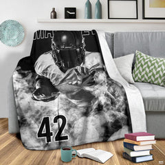 Grayscale football player graphic blanket displayed on armchair