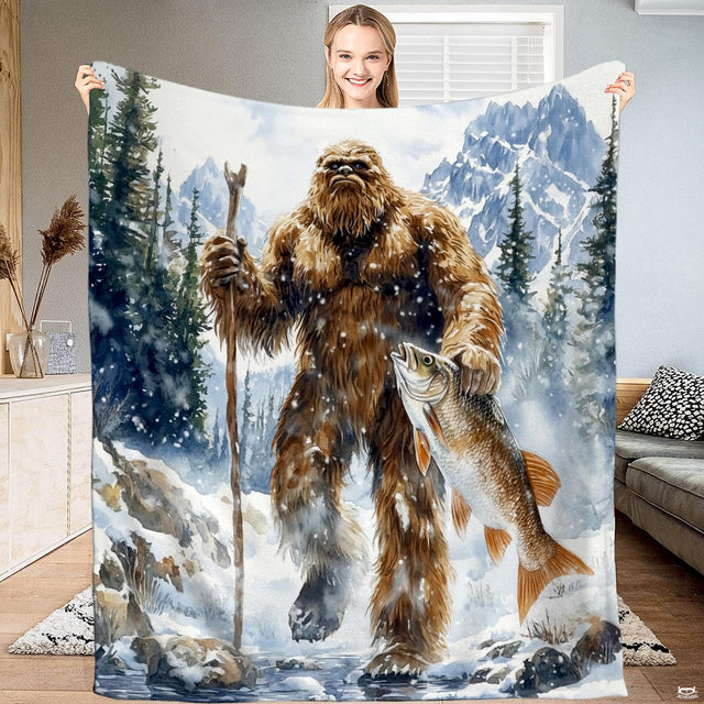 Woman holding up display showing watercolor Bigfoot holding fish in snowy mountain landscape.