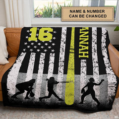 Distressed flag softball print arranged across a couch in front of a bright room window.