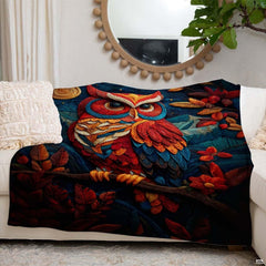 Side angle perspective showing saturated crimson and navy tones of the owl blanket