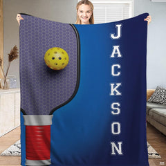 Honeycomb pickleball paddle with yellow ball on blue gradient, view 2.