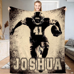 Football player silhouette throw blanket held upright showcasing charging athlete artwork and splatter textures.