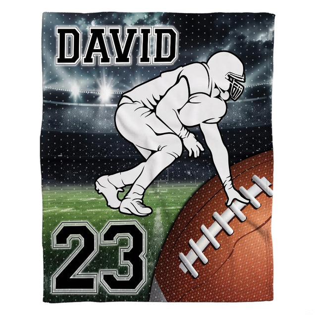 Woman holding open football lineman throw blanket showing nighttime stadium and varsity lettering